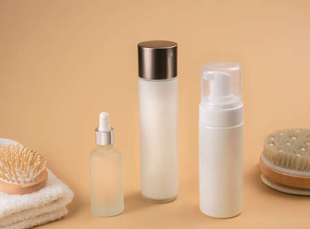 bottles with cosmetic foam or gel on beige background, selective focus. Mockup for branding and packaging presentation. beauty and spa conceptの写真素材