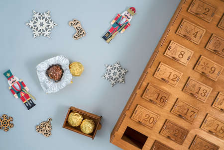 wooden advent calendar with sweets and wood decorations on the treeの写真素材