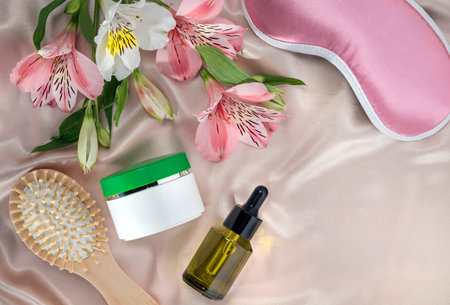 daily skincare before bedtime, moisturizer or nourishing cream, serum and sleep mask on a silk backgroundの写真素材