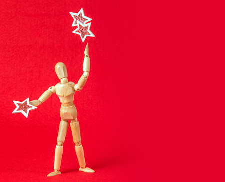 Business and design concept - wooden mannequin with stars on a red backgroundの写真素材