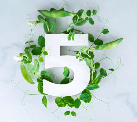 Layout with sprouts of green peas, leaves and number. Top viewの写真素材