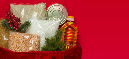 sack of Santa Claus with various groceries. Cereals, sunflower oil, canned food. Copy space. Flat lay.の写真素材