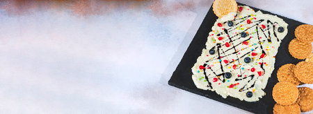 Sweet Butter board topped with chocolate, pomegranate seeds, blueberries.の写真素材