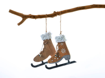 Christmas decoration in the form of a pair of skates hanging on a tree branchの写真素材