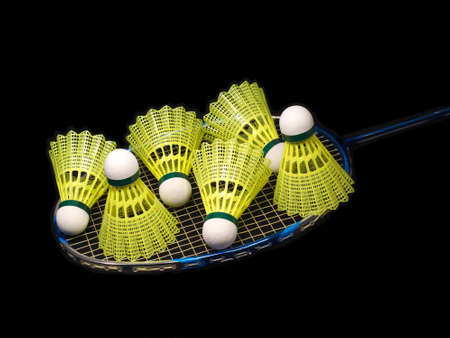 Badminton racket wit six yellow shuttlecock isolated on blackの写真素材