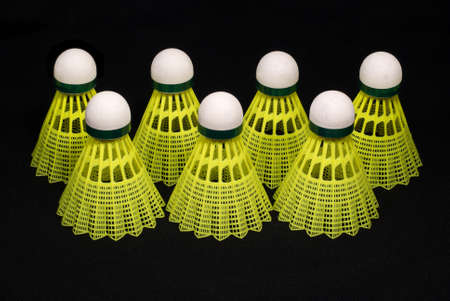 Seven yellow badminton shuttlecocks isolated on blackの写真素材