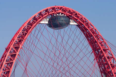 Large arched red bridge with viewing cabin and ropesの写真素材