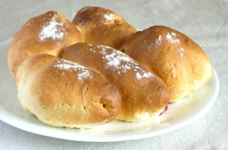 Tasty pies with jam on white plate over tablecloth close upの写真素材