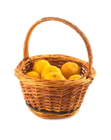 Many orange tangerines in brown wicker basket isolated on white closeup