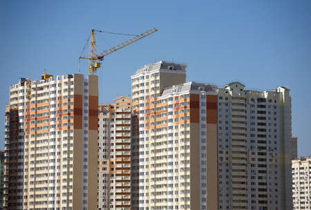 New high-rise buildings constructing in process over clear blue cloudless sky