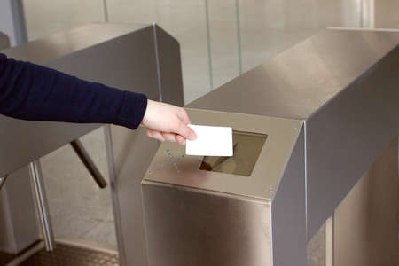 Woman s hand puts a white plastic card to the reader access control space closeup