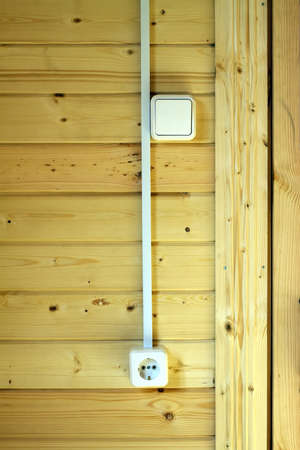 Electrical sockets, switches and wiring on wooden wall in new country house  Photo closeup