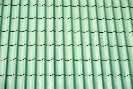 Green metal tile house roof as texture closeup