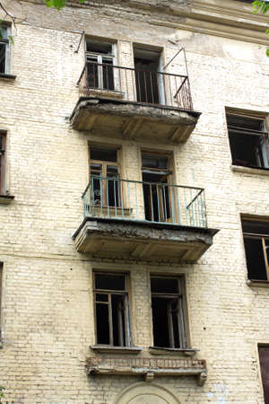 Abandoned uninhabited house with broken windows and balconies before renovation front view vertical closeupの写真素材