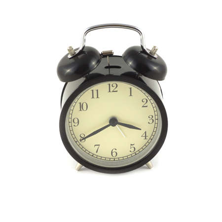 Alarm clock in black case shows about four o\'clock. Photo isolated on white close upの写真素材
