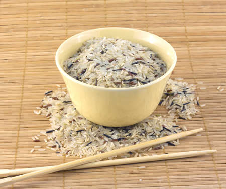China color rice and beige bowl with chopsticks on brown straw mat closeup