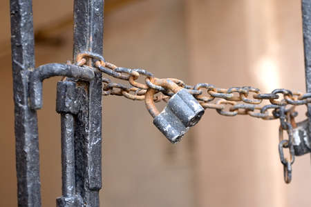 Old metal padlock hangs outdoors on metal fence on blur background closeupの写真素材