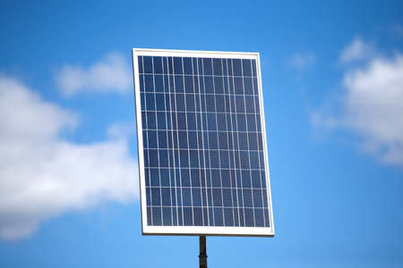 Single big vertical solar panel over blue sky with blur clouds