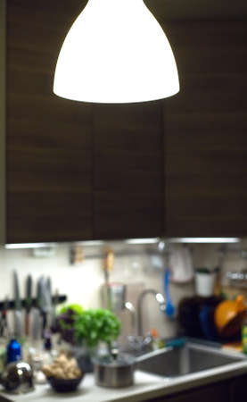 Fragment of modern kitchen interior with wooden furniture and different kitchen equipment with focus...