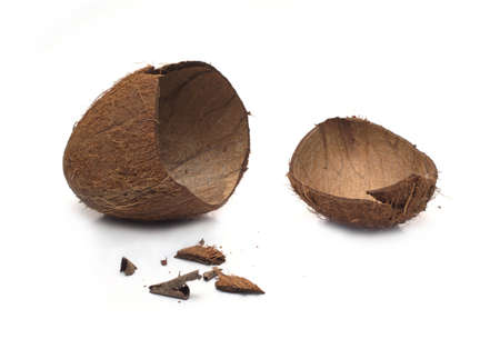 Still life with empty broken coconut shell and smithers isolated on white background. Horizontal close-up photoの写真素材
