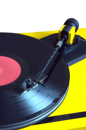 Turntable in yellow case playing a vinyl record with red label. Vertical photo isolated on white...