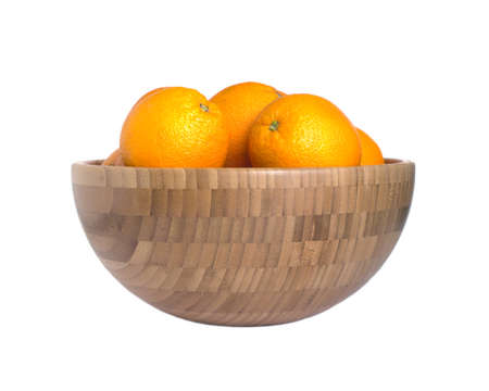 Many ripe appetizing oranges in big brown wooden bowl isolated on white background. Front view closeupの写真素材