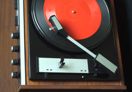 Old vintage vinyl record player in brown wooden case. Top view horizontal photo closeup