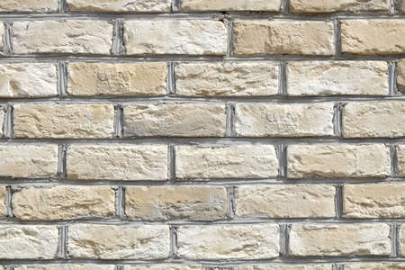 Wall from beige bricks front view closeup horizontal photo