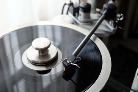 Graphite tonearm of vintage turntable with LP record close up viewの写真素材