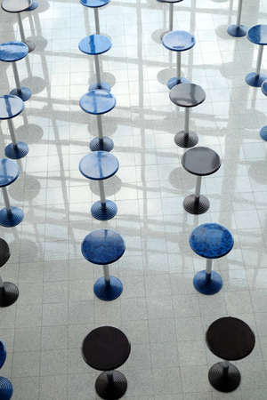Abstract composition with many round eating tables staying in empty cafe hall vertical top view