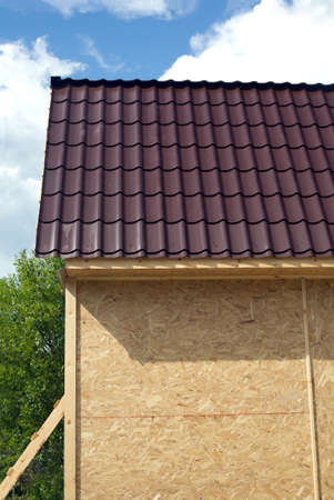 Suburban house construction with OSB panels on sunny summer day side view