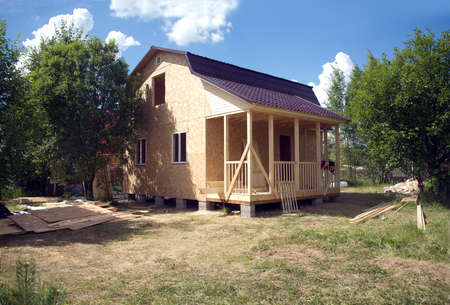 Suburban house construction with OSB panels on sunny summer day side viewの写真素材