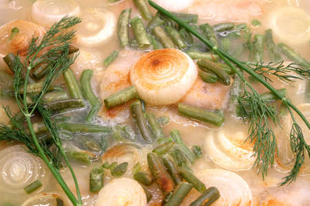 Prepared fried fish with onion, green beans and spices and dill closeupの写真素材