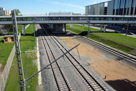 Urban industrial landscape railroad tracks, platform and elevated pedestrian crossing on sunny summer day top viewの写真素材