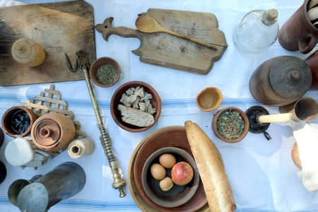Still life with rural repast of antique french wood and metal utensils, vintage scales and simple...