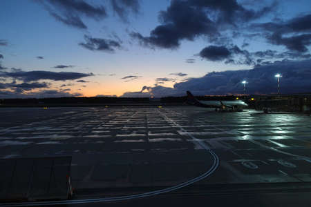 Beautiful colorful sunset in airport area with lighting in the evening before dark clouds on horizon