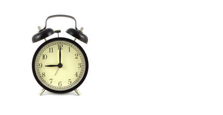 Alarm clock in black case shows 9 o'clock isolated on white background front view close up with free...