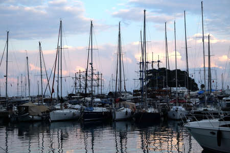 Marine with many different sea yacht parking in calm water in the evening with reflection in water...