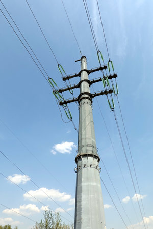 High-voltage strong power line metal prop painted gray with many wires on electrical insulation view from bottom to top close upの写真素材