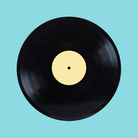 Black long-play vinyl record with yellow label isolated on cyan background front view closeupの写真素材