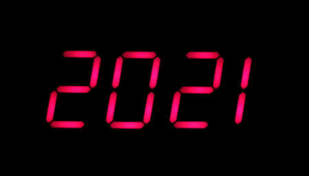 New year date. Big red arabic numerals on display shows 2021 isolated on black background front view horizontal close upの写真素材