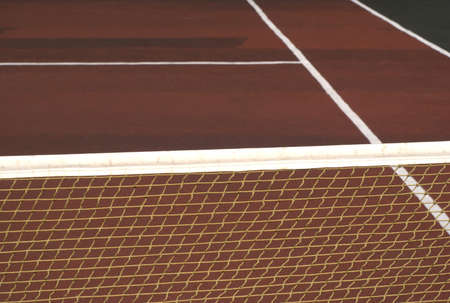 Tennis net on empty court with brown surface front view close upの写真素材