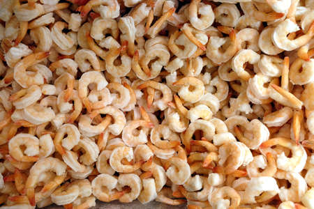 Still-life with lot of frozen peeled pink-white shrimp as background in the freezer in department store shop top view close-upの写真素材
