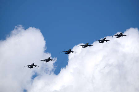 MOSCOW, RUSSIA - MAY 7, 2021: Group of six Russian military tactical frontline bombers SU-25 Frogfoot fast flying on parade rehearsal in blue sky with white cloudsのeditorial素材