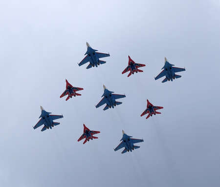 MOSCOW, RUSSIA - MAY 7, 2021: Airplanes of aerobatic groups Russian Knights and Swifts on MIG-29 and SU-27 fighters flights on parade rehearsal in the cloudy skyのeditorial素材