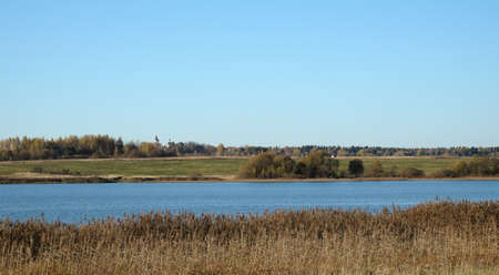 Calm quiet blue rural river with panoramic view to other coast in the beginning of the autumnの写真素材