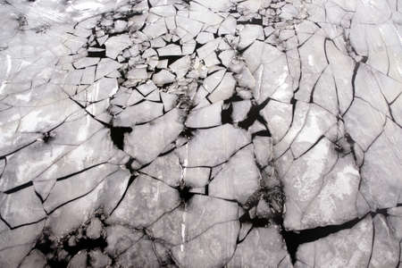 Broken ice floats floating on the river aerial view from droneの写真素材