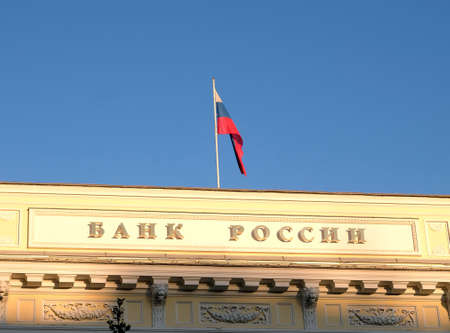 Building of Central Bank of Russia in Moscow with state flag on the top of the building under clear...