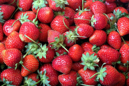 Crop from many red ripe strawberries as background top view close upの写真素材