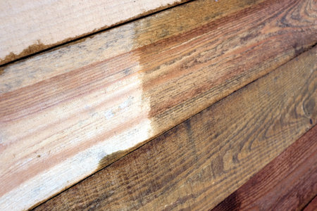 Repair of wooden wall by boards painting close up side viewの写真素材